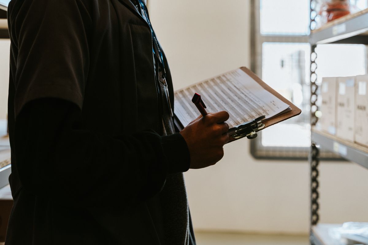 Worker checking inventory against a document